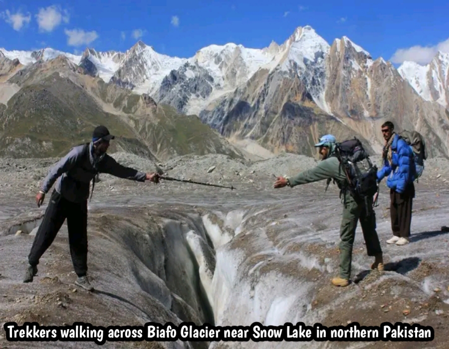 Trekkers walking across Biafo Glacier near Snow Lake in northern Pakistan